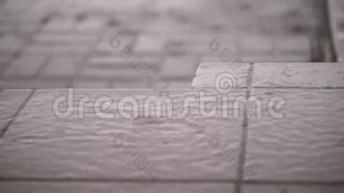 特写，有大雨，一阵阵雨，大的大雨滴在街道瓷砖上.. 雨滴湿地板的质地